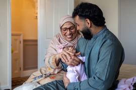 Grandparents smiling at new baby