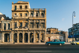 Photo of building in Cuba with cars parked in front