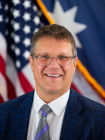 Headshot of Commissioner Joseph Sullivan in front of a MN & U.S. Flag