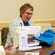 Woman using a sewing machine to fix garment