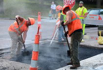 public works employees repairing section of road