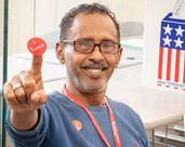 Man holding "I voted" sticker
