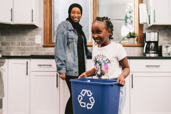 Mother and daughter with recycling bin