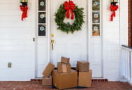 Packages sitting outside a front door decorated for the winter holidays