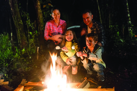 Hispanic family sitting around a backyard fire
