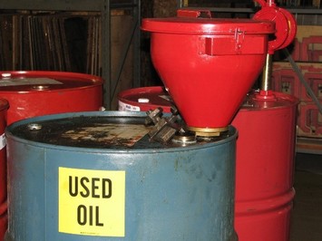 Metal container labeled with the words "used oil" and a red funnel attached at the top