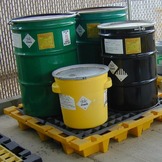 Four hazardous waste containers that are properly labeled and closed