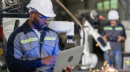 Engineer using computer in manufacturing plant