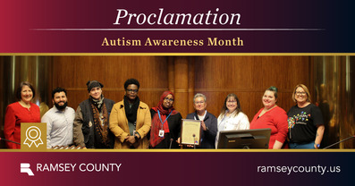 Commissioners pose in photo with staff for Autism Awareness Month