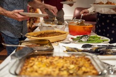 Potluck event with variety of food items displayed on table