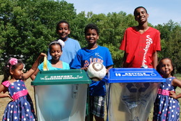 Group of kids standing next to two ClearStream recycling and compost containers