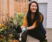 Woman holding potted plant in her garden.