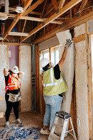 Kelly installing insulation at Habitat home