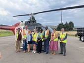 MMCD Committee in front of a helicopter used to spray for mosquitos
