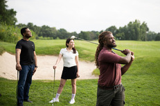 Three people playing golf