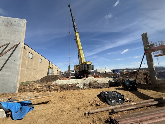 A construction crane working on the wall of the new Maintenance Bay addition.