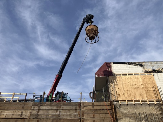 A drill rig assists with the elevator sleeve.