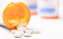 orange pill bottle with opioids spilling out