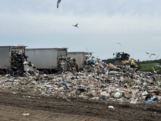 Multiple trucks hauling waste from Resource Renew empty their trash onto the working face of the St. Louis County Landfill in Virginia.