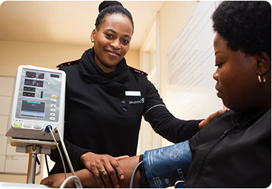 Nurse checking a patient's blood pressure. Preventive and wellness services are essential health benefits.