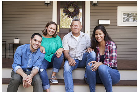 parents with young adult children sitting on steps outside their front door