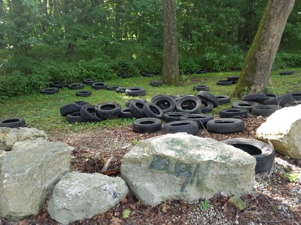 A large illegal dump of tires under trees at Stringtown Bridge Access in Cole County