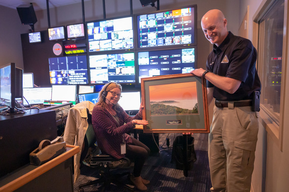 MDC Outreach and Education Chief Shawn Gruber presents the award to show producer Peggy Dierssen in the Fox 2 control room.