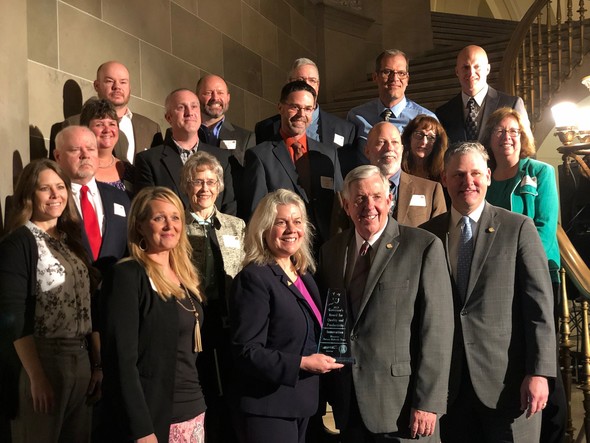 MDC Director Sara Parker Pauley poses with Governor Mike Parson and the Discover Nature Schools team after winning the Award for Innovation.