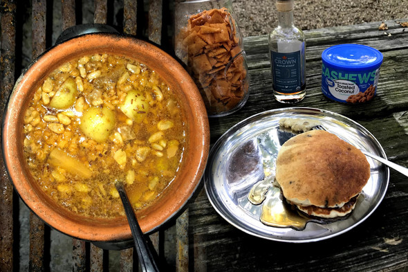 Two completed outdoor cooking food dishes are displayed on an outside table.