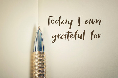 Close up of gratitude word with pen on notebook