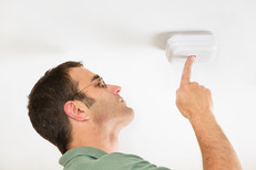 Man checking smoke alarm