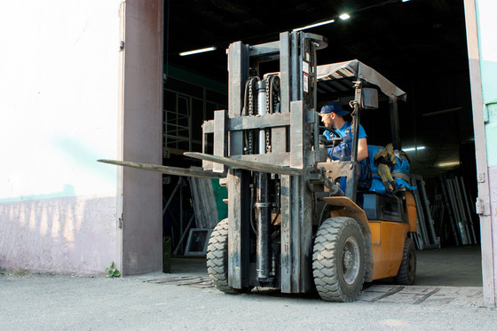 Man driving forklift out of a warehouse