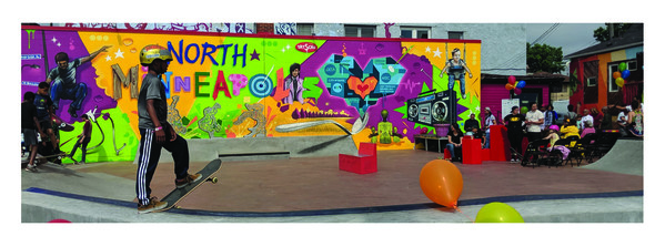 Juxtaposition Arts skate plaza decorated with ballons with people skateboarding and socializing