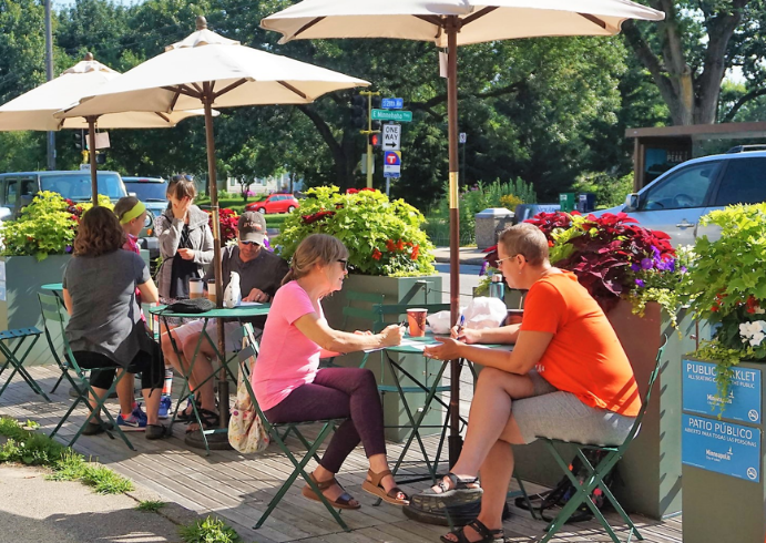 People dining at a street cafe in a parklet