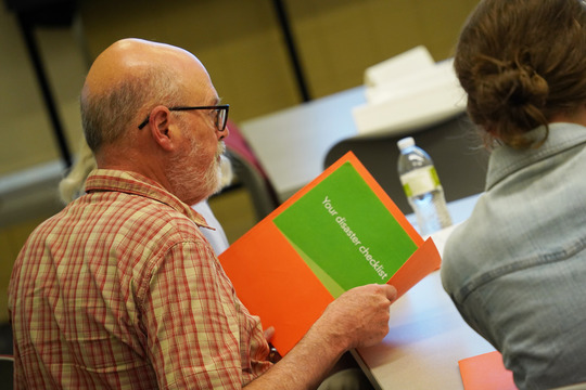 A community member reads through resources and materials provided at Ready Camp.