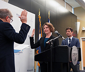 Director Rachel Sayre takes the oath of office, led by the city clerk, to confirm her appointment. 