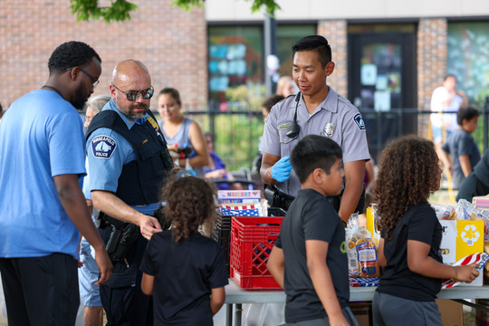 Minneapolis Police Department officers engaging with community members at an outreach event.