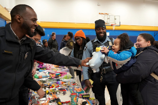 MPD officers smile as they hand out toys to community members at the annual Holiday Toy Giveaway on Dec. 23.