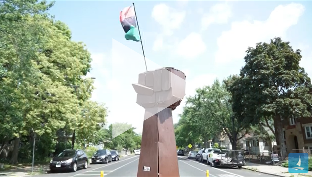 Video preview of "Minneapolis: Five years later" reflections; Raised wooden fist sculpture featured