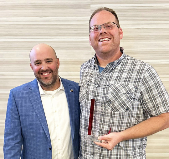 MNIAAI President Brian Whitmore (left) presents Minneapolis Fire Investigator Andrew Moe (right) with the Investigator of the Year Award on May 16.