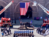 Officers and city leadership salute the American flag in front of City Hall. Photo from the 2023 Hennepin County Law Enforcement Ceremony.