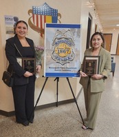 Two MPD Community Navigators stand with awards at a banquet