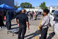 A group of people and officers playing an outdoor game.