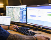 A 911 Emergency Communications Center telecommunicator looks at monitors as they work