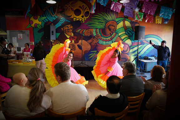 Two people in colorful dresses, dancing at the 2024 Latino Business Week opening event