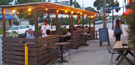 people dining in at a street cafe on a city street