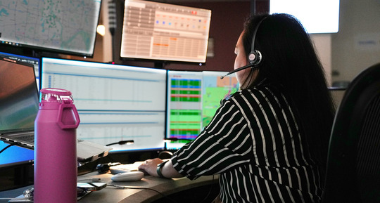 An image of a 911 telecommunicator working on a computer