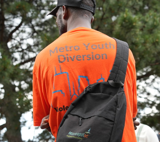 The back of a Metro Youth Division member’s shirt is shown during a MinneapolUS Violence Intervention walk-along