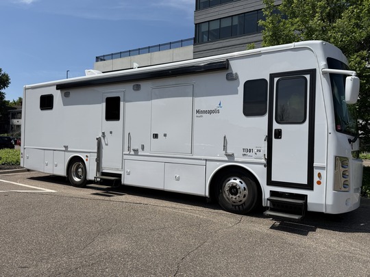 An exterior photo of the City of Minneapolis Mobile Medical Unit, a white vehicle with a Minneapolis Health logo on the side.