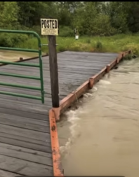 Flood waters threaten to overtop a bridge in recent Lake County flooding near Polson, Montana